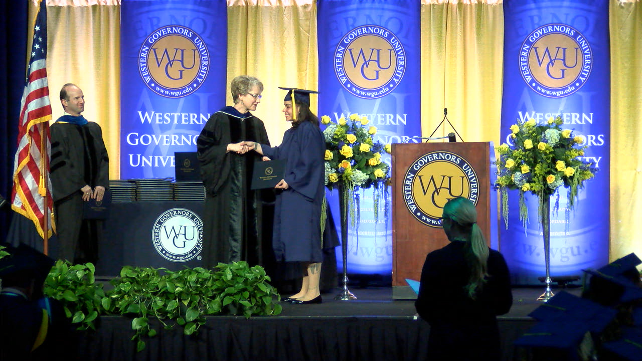 Dean presenting a diploma to a student at Western Governors University graduation