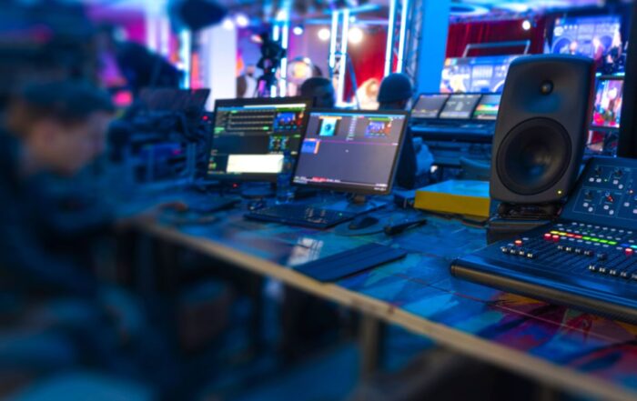 table with live streaming equipment on it and a crew member sitting there.